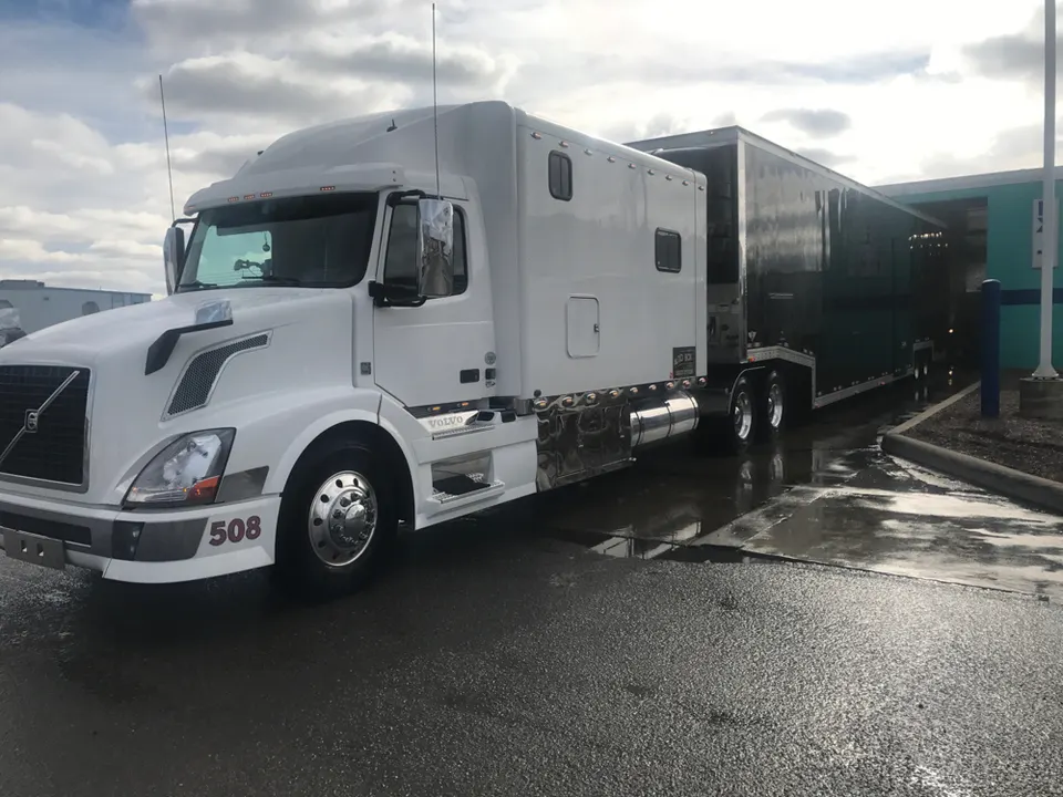 An AutoBox Express tractor and enclosed trailer parked outside the terminal